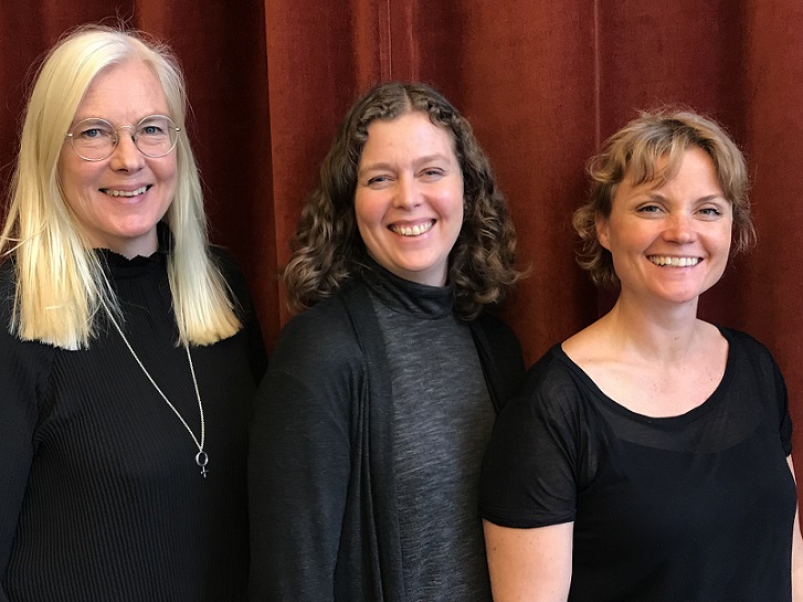 Tre podcastdeltagare ler mot kameran och står framför en röd sammetsgardin