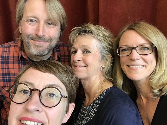 Tre podcastgäster och programledaren står framför en röd sammetsgardin